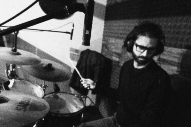 Drummer wearing headphones in the rehearsal room, black and white