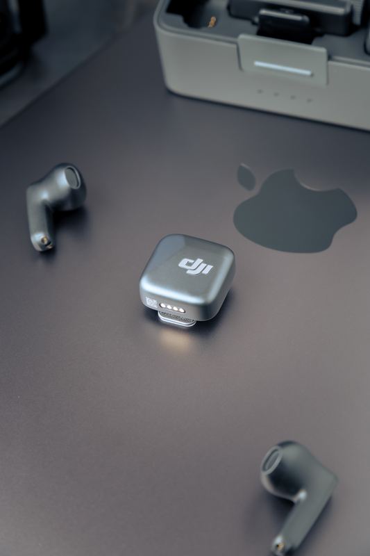 Microfono wireless e auricolari su superficie scura, fotografia di prodotto tech